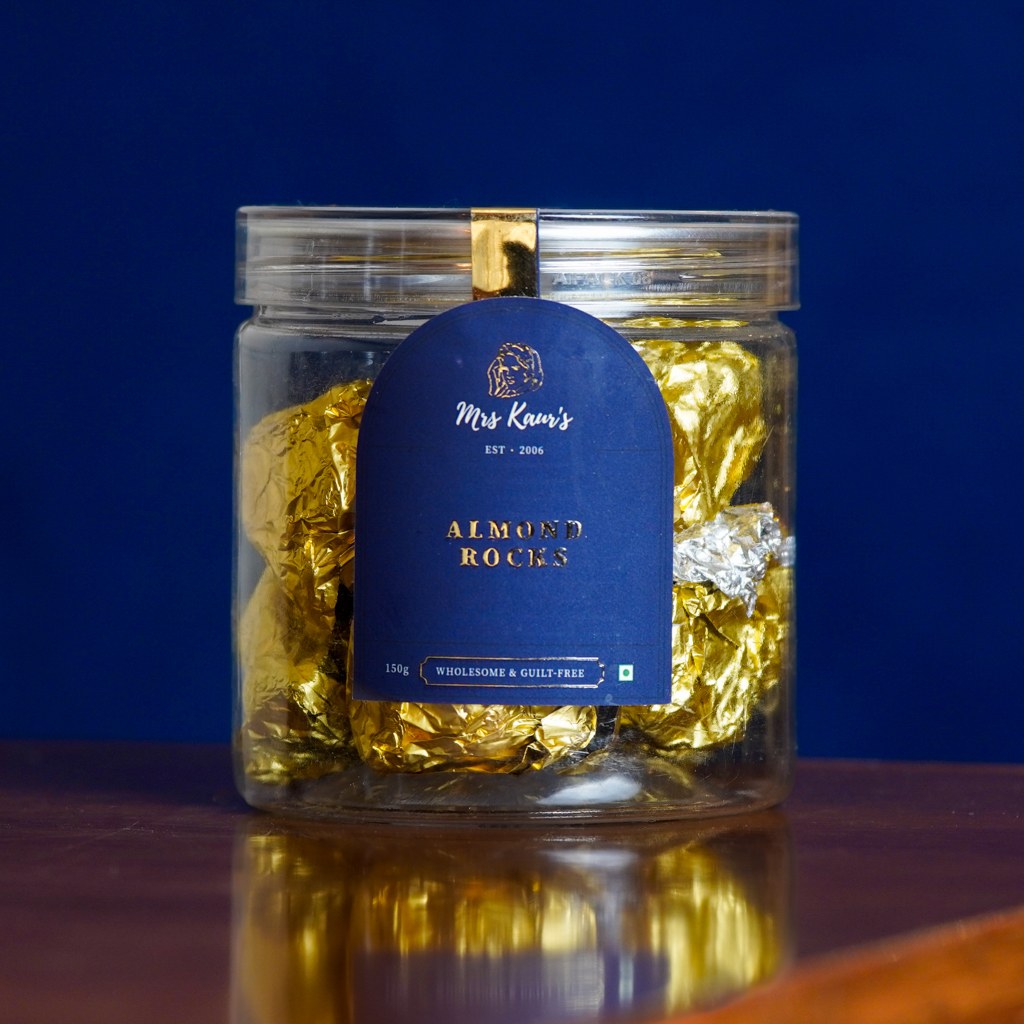 Almond Rocks wrapped in gold and silver foil, in a clear Mrs Kaur’s jar