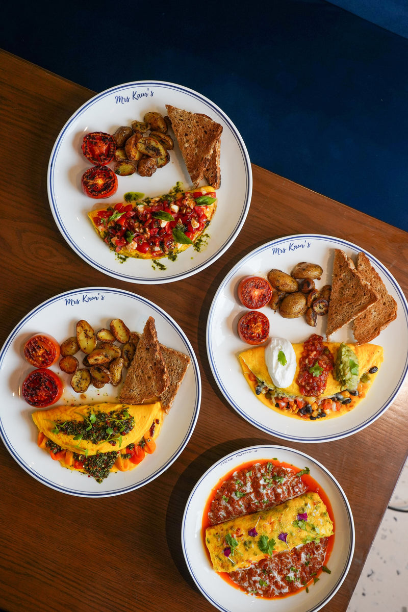 Four omelette plates on a walnut table at Mrs Kaur’s